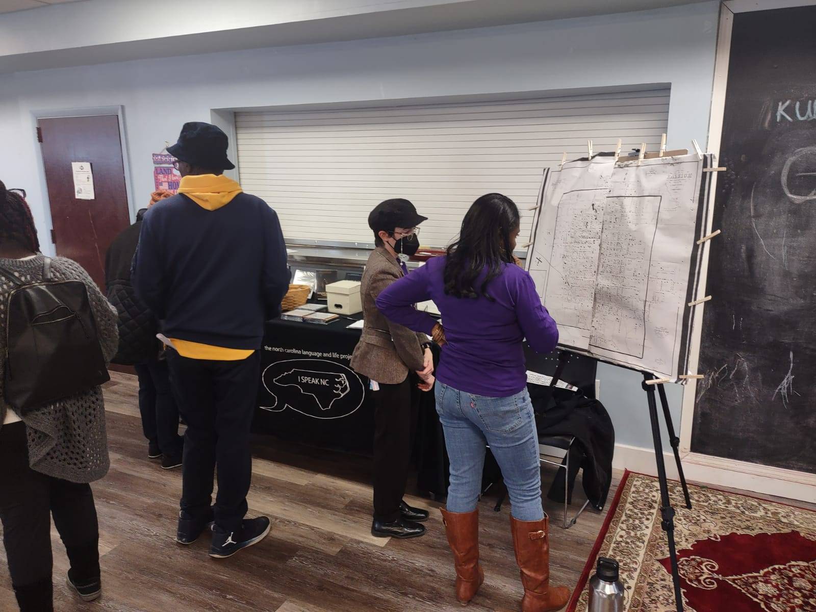 Haley Kinsler and Ikeya Kearney-Williams, secretary for the neighborhood association, look at a historic map of Raleigh together